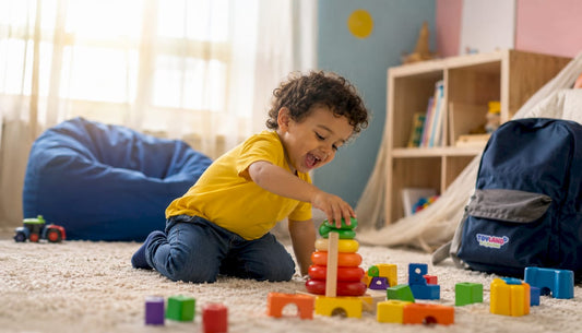 Toddler playing on carpeted floor with toys