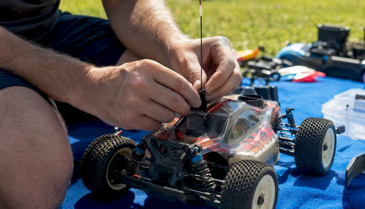 Hands routing RC car antenna outdoors