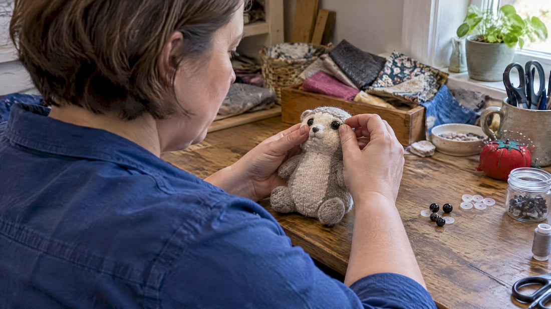 Maker inspecting safety eyes on plush toy